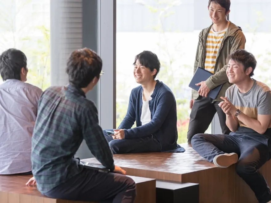 パソコンの画面を見ながら打ち合わせをする社員たち